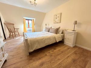 a bedroom with a bed and a chair in it at Daisy Cottage with seasonal Swimming Pool in Le Mesnil-Gilbert +36 photos