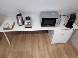 a white desk with a microwave and a toaster at Suite La Marquise in Murol