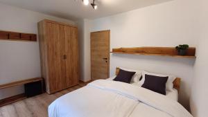 克拉尼斯卡戈拉Apartment HANI的一间卧室配有带白色床单和黑色枕头的床。