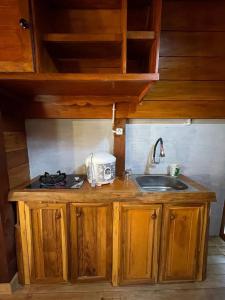 a kitchen with a sink and a stove at Griya Keboen Dieng in Diyeng