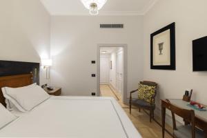 a bedroom with a bed and a desk and a chair at Grand Hotel Parker's in Naples