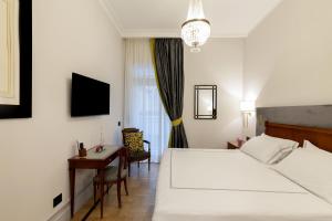 a hotel room with a bed and a desk and a table at Grand Hotel Parker's in Naples