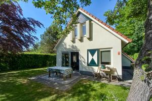 a small white house with a table in the yard at Vakantiepark Drentse Vennen in Een-West