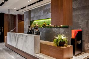 a lobby with two people standing at a reception desk at Wonstar Hotel in Taipei