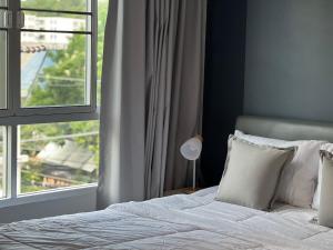a bedroom with a bed and a large window at Baan Peang Ploen Takiab Beach by Cloud9Stays in Hua Hin +6 photos