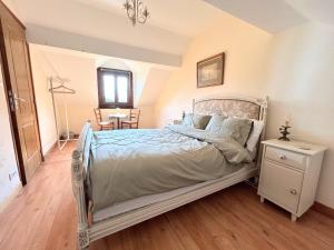 a bedroom with a bed and a table at Rose Cottage with seasonal Swimming Pool in Le Mesnil-Gilbert +35 photos