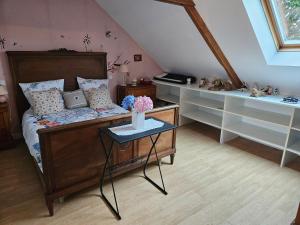 a bedroom with a bed with a table and shelves at Chambre d'hôte à coté de la voie verte in Gourin