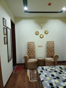 a bedroom with two chairs and a bed and a tv at One bed furnished appartment in Darwāla