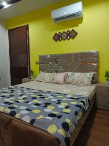 a bedroom with a bed and a air conditioner on the wall at One bed furnished appartment in Darwāla