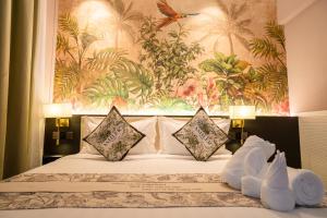 a bedroom with a bed with a painting on the wall at The Palm Suite Tanjung Tokong in George Town