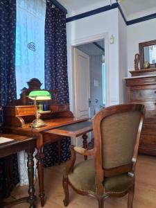un bureau avec une lampe et une chaise dans une pièce dans l'établissement La Maison de Coraline, à Lu