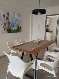 Un comedor con una mesa de madera y sillas blancas. en De cara al lago Bariloche U4, en San Carlos de Bariloche 15 fotos más