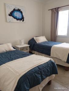 Un dormitorio con dos camas y una ventana. en De cara al lago Bariloche U4, en San Carlos de Bariloche