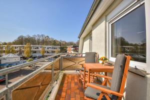 a patio with a table and chairs on a balcony at Haus Kehrwieder Leuchtturm in Grömitz