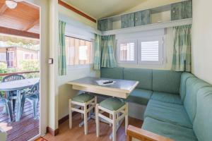 Una mesa pequeña y un banco en una casa diminuta en Bungalow A2, en Pontevedra