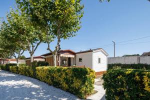 una pequeña casa blanca con árboles y arbustos en Bungalow A4, en Pontevedra