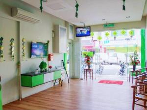 a room with tables and chairs and a tv on the wall at Asia Green Hotel in Sungai Besar +12 photos