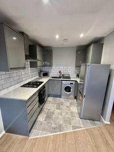 a kitchen with stainless steel appliances and a tile floor at Immaculate 2 bed flat with free parking! in Watford