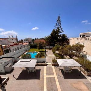 two tables and chairs on a patio with a pool at Zen Den Coliving - For Digital Nomads Only in Arona