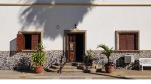 a house with potted plants in front of a door at Zen Den Coliving - For Digital Nomads Only in Arona