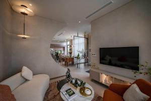 a living room with a large flat screen tv on a wall at Villa The Bee - Dự án iD Junction Long Thành in Long Thành