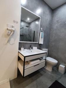 a bathroom with a sink and a toilet and a mirror at Cantinho d sossego -Two bedrooms apartment in Mindelo