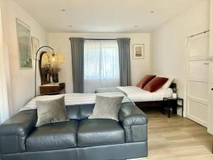 una sala de estar con un sofá y una cama en Beachside Studio With Courtyard, en Birchington