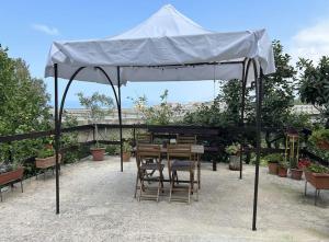 un tavolo e delle sedie sotto un ombrellone bianco di Casetta a Cavarretta a SantʼAgata di Militello
