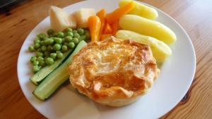 a plate of food with peas and vegetables on a table at Ashdowns of Dover in Dover