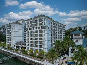 a large white building next to a river at Seaview Suites at Admiral Bay in Port Dickson