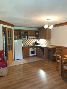 a kitchen with wooden cabinets and white appliances at Superbe appartement 8 personnes au pied des pistes in Oz