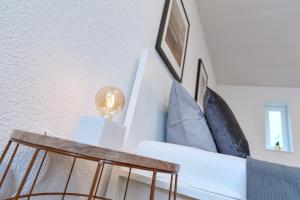 a living room with a white couch and pillows at Haus Kehrwieder 9 Bungalow in Grömitz