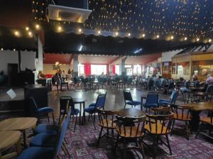 a dining room with tables and chairs and lights at 200 Breakaway Chalet in Scratby