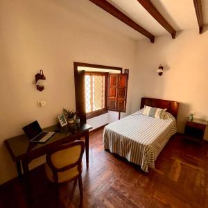 a bedroom with a bed and a desk with a laptop at Zen Den Coliving - For Digital Nomads Only in Arona