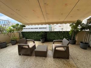 a patio with chairs and a table and plants at Central Elegant Flat in Patra