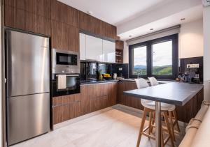 a kitchen with a stainless steel refrigerator and a table at The High View Ioannina in Ioannina