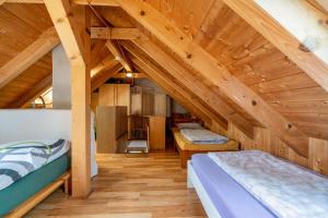 deux lits dans une chambre avec plafonds en bois dans l'établissement Kletterhütte Sächsische Schweiz, à Lohsdorf