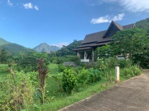 a house with a garden next to a road at Villa Mae Hong Son in Mae Hong Son