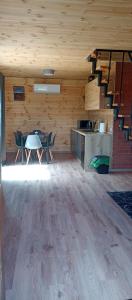 a room with a table and chairs and a staircase at Chatka Karpatka in Kostrzyca