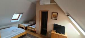a small room with a tv and a bedroom at Penzion Romance in Břeclav