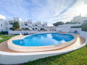 a large swimming pool in a yard with buildings in the background at Casa Joao in Carvoeiro