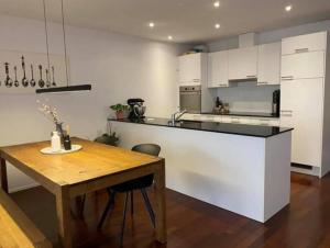 a kitchen with a wooden table and a white counter top at TOP Ferienwohnung in Aadorf