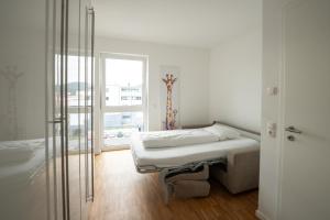 a white room with a bed and a window at Prime Park Penthouse Aschaffenburg in Aschaffenburg