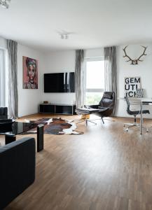 a living room filled with furniture and a flat screen tv at Prime Park Penthouse Aschaffenburg in Aschaffenburg