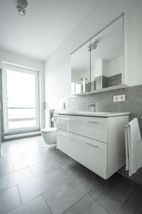 a white bathroom with a sink and a toilet at Prime Park Penthouse Aschaffenburg in Aschaffenburg