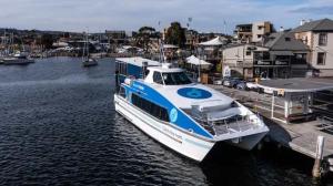a blue and white boat docked at a dock at Mountain View Villa-close to shops-10min to CBD in Bellerive
