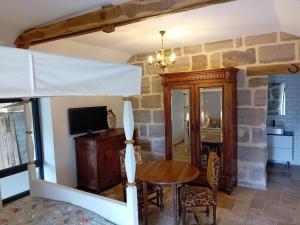 a dining room with a table and a tv at Le Forestier - 1 Pièce in Brive-la-Gaillarde