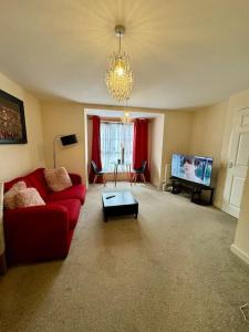バーミンガムにある2bdroom city center house Perfect for contractorsの赤いソファとテレビのあるリビングルーム