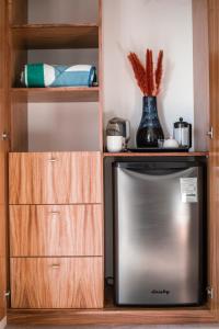 a kitchen with a refrigerator and a wooden cabinet at Villa Damiana Luxury Hotel in El Pescadero
