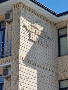 撒马尔罕OLD STATION HOTEL的砖砌建筑侧面的标志